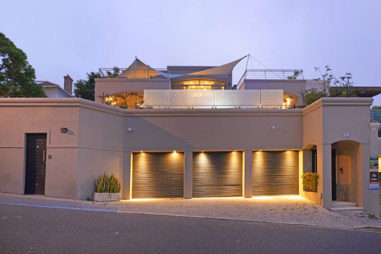 Contemporary Cape Town home exterior with triple garage at twilight