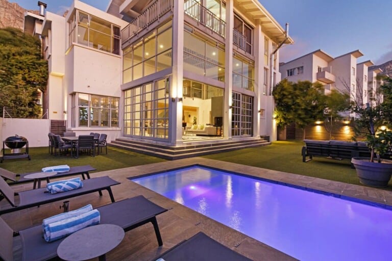 Modern Cape Town villa with infinity pool and outdoor terrace at dusk — Business-Ready City Stays